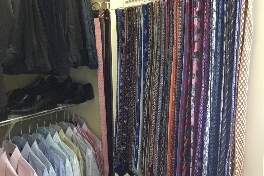 Organized closet with neatly hung ties, dress shirts, and shoes on shelving
