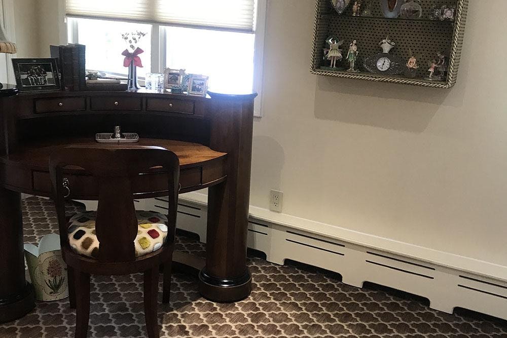 Home office with dark wood desk and patterned rug
